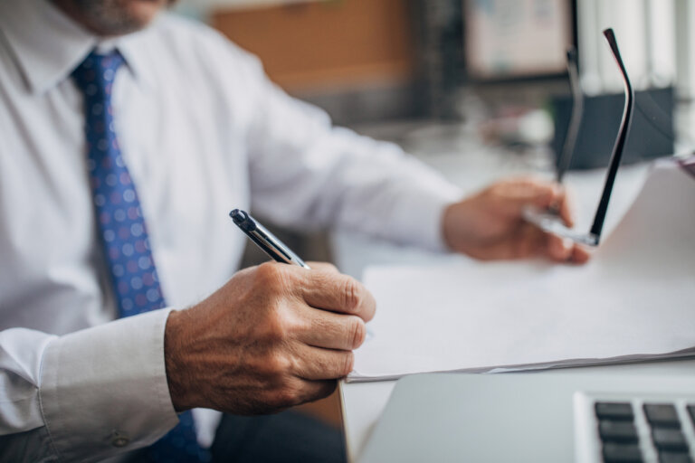 man with glasses and pen in hand